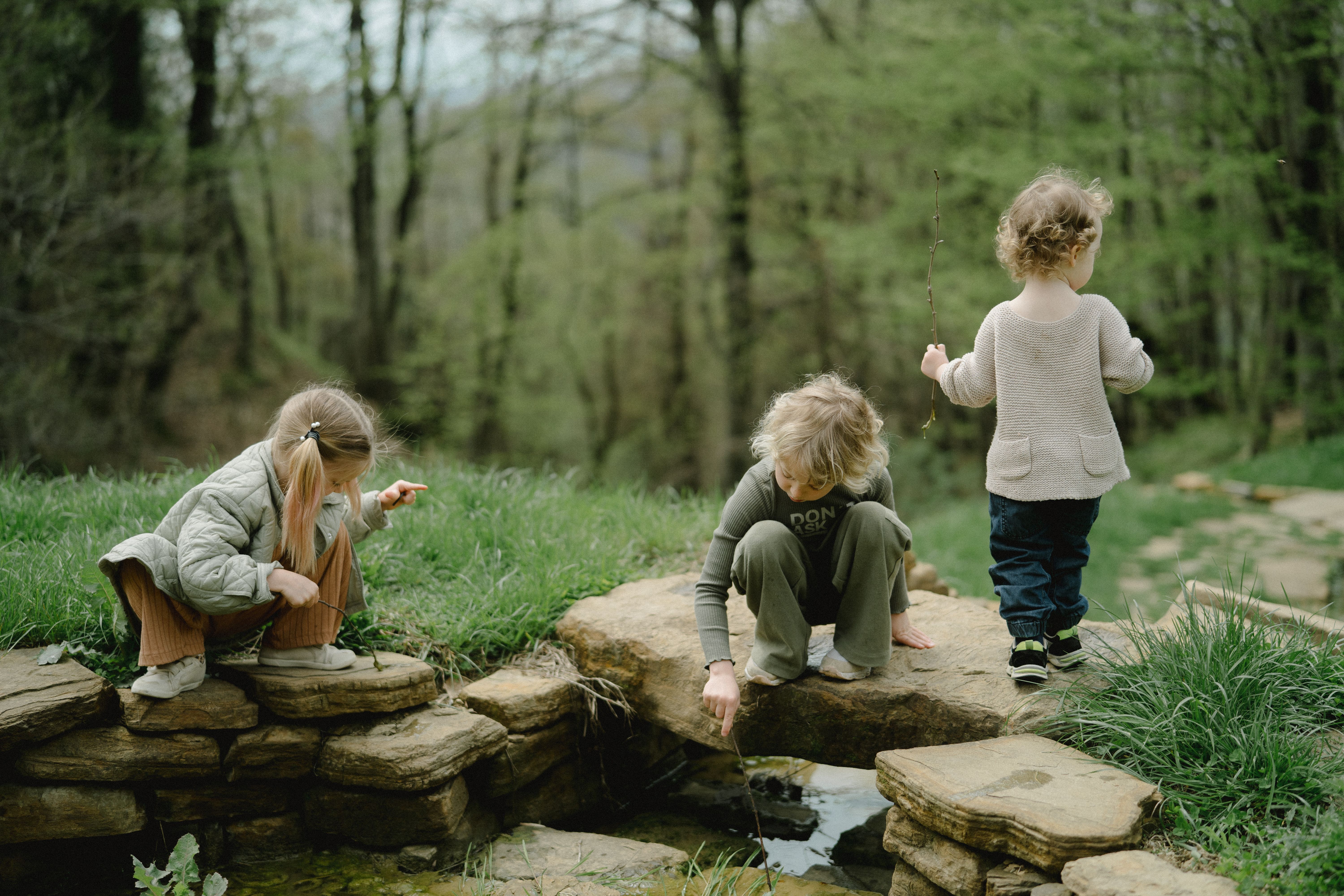 Kinder spielen draußen in der Natur am Wasser
